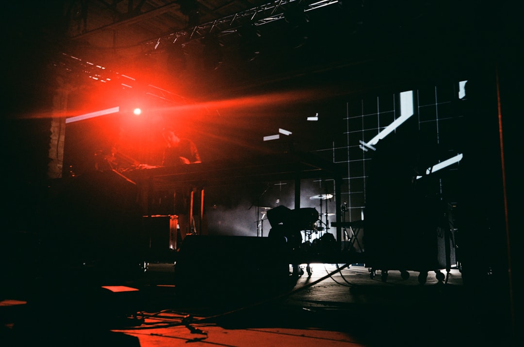 a red light shines on a stage as a band plays