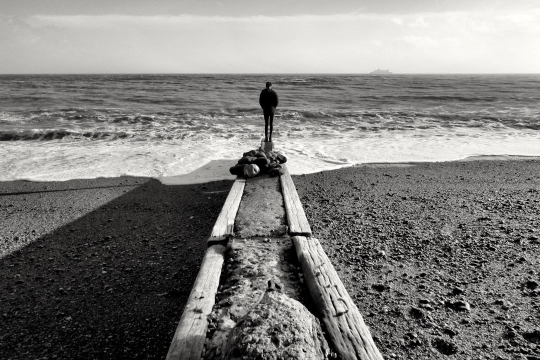 A boat sitting on top of a beach next to the ocean